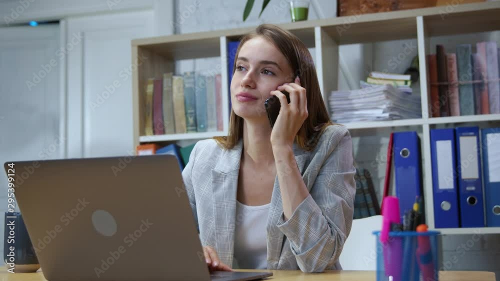 Portrait of cheerful office girl talking on smartphone with a friend laughing during break at work. Positive female employer in working space. Portrait of cheerful office girl talking on smartphone with a friend laughing during break at work. Positive female employer in working space.