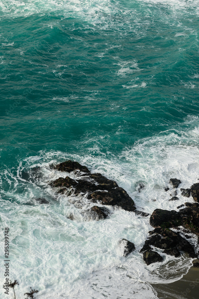 Obraz premium Teal Waters Crash onto Rocks in Pacific