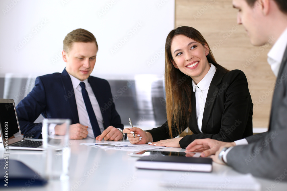 Businessman and woman with colleague sitting and working at the glass desk. Diverse business people discussing questions at meeting or negotiation in modern office. Teamwork and multi ethnic group Businessman and woman with colleague sitting and working at the glass desk. Diverse business people discussing questions at meeting or negotiation in modern office. Teamwork and multi ethnic group
