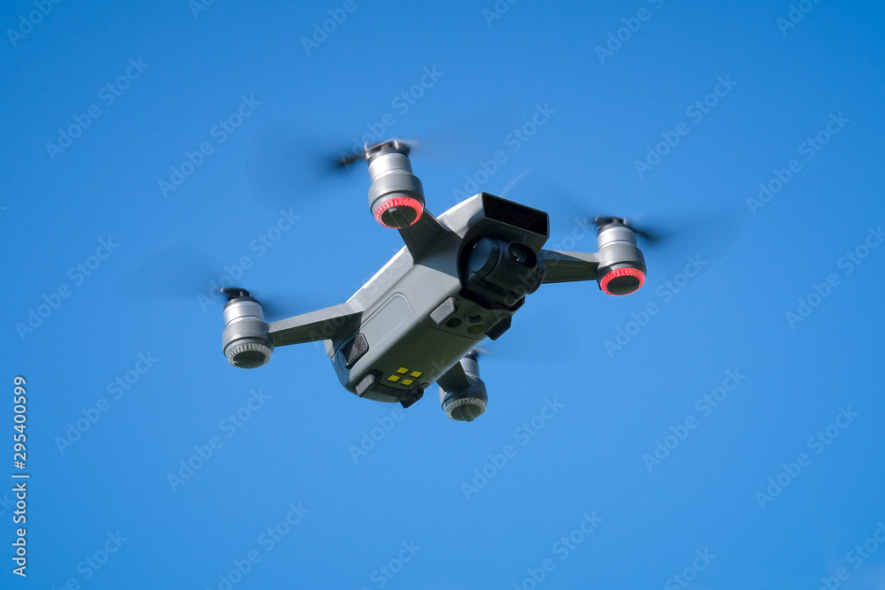 Small drone hovering against blue sky Small drone hovering against blue sky