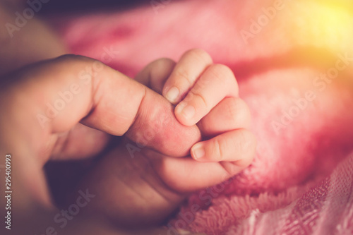 New born baby hand hold her mom's finger
