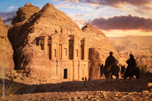 Monastery (Ad Deir) at sunset with silhouettes of Bedouins riding donkeys, Petra, Jordan