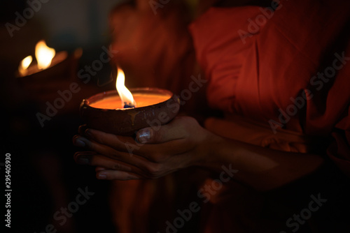Buddhist monk hands holding candle cup in the dark   ,Chiang mai , Thailand