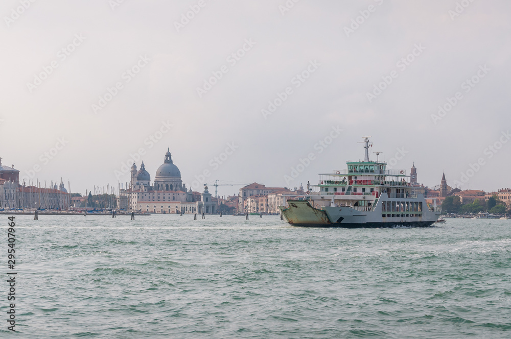 Grand canal with boat and St Maggiore church on the background