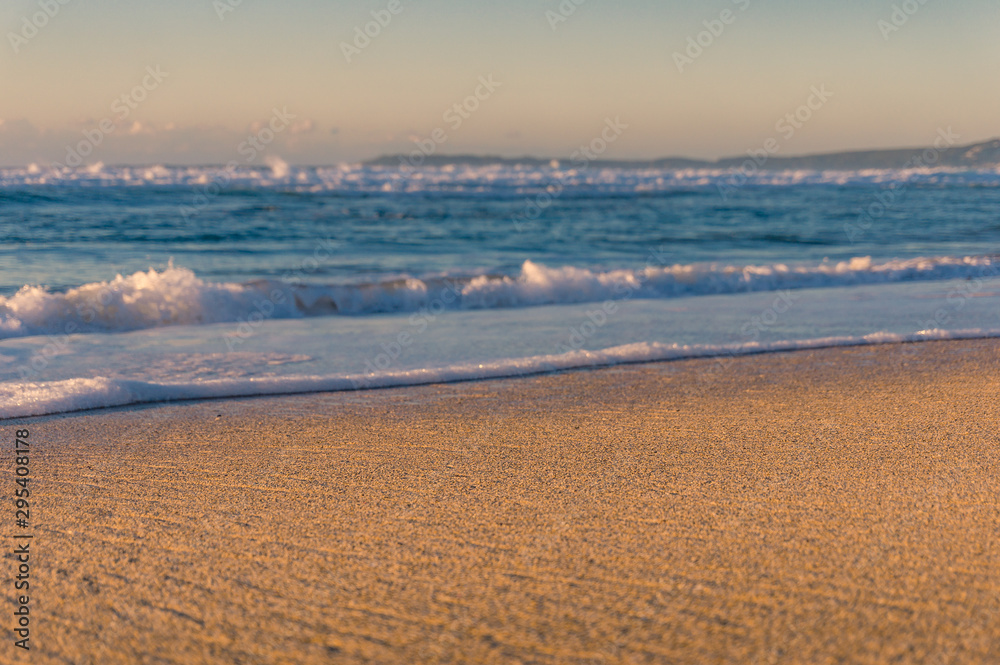 Tropical beach background with soft blue waves at sandy shore