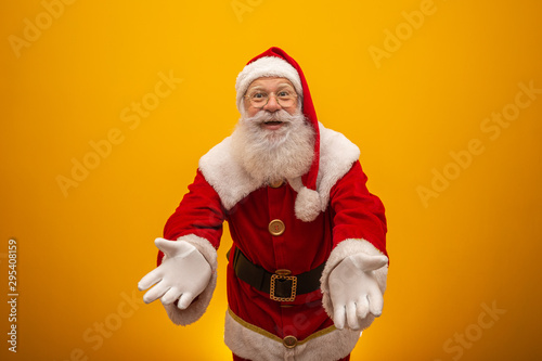 Santa Claus on yellow background with copy space. Presenting.