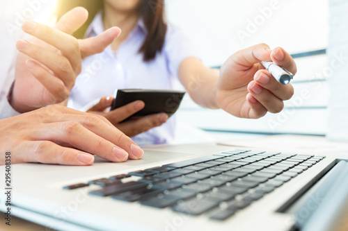 Team meeting businessman hand working with ptop with tablet on withe desk at office warm colours sun light photo