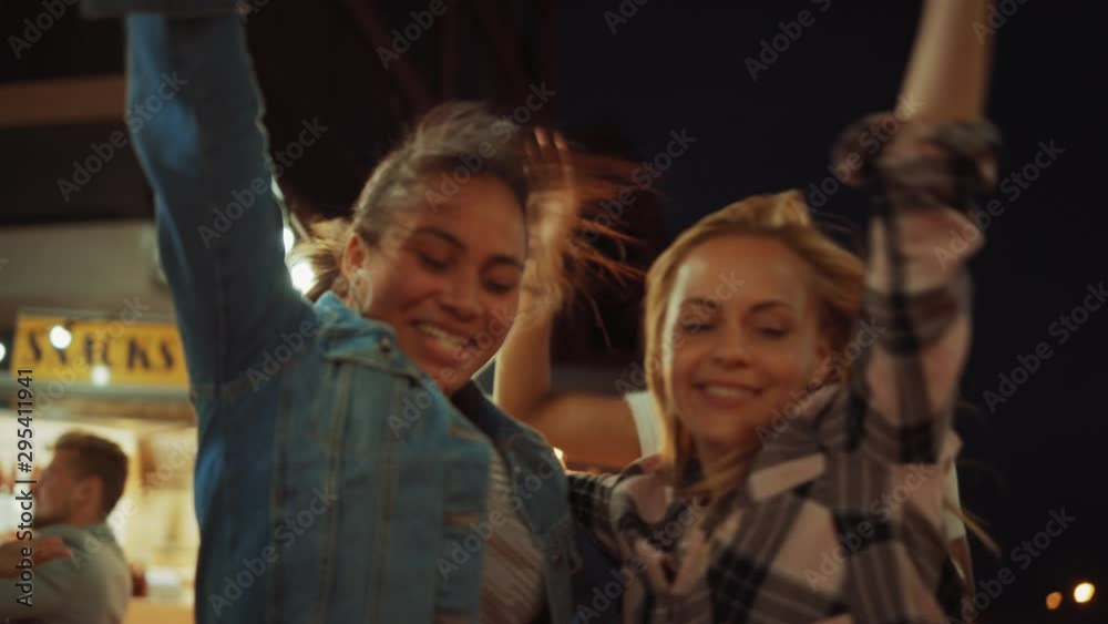 Group of Friends are Having a Party Outside a Street Food Burger Cafe. Two Beautiful Girls Hugging and Dancing to Music. It's Evening in a Modern Neighbourhood. Everybody are Happy and Full of Joy. Group of Friends are Having a Party Outside a Street Food Burger Cafe. Two Beautiful Girls Hugging and Dancing to Music. It's Evening in a Modern Neighbourhood. Everybody are Happy and Full of Joy.