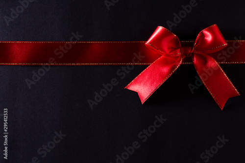 Top view of red ribbon on black background with copy space for text. black Friday and Boxing Day composition.