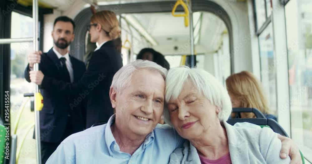 Portrait of the happy Caucasian old couple sitting in the tram and going somewhere while hugging and smiling. Close up. Portrait of the happy Caucasian old couple sitting in the tram and going somewhere while hugging and smiling. Close up.