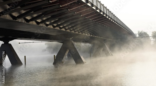 steam from the river under the bridge in the early morning