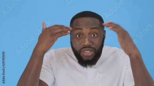 angry frustrated man with raised arms, expressing his disagreement. close up portrait, isolated blue background, studio shot. conflict, discussion 4K
