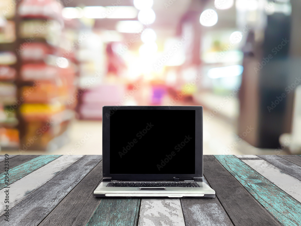 laptops on desk with blur shelves in supermarket background laptops on desk with blur shelves in supermarket background