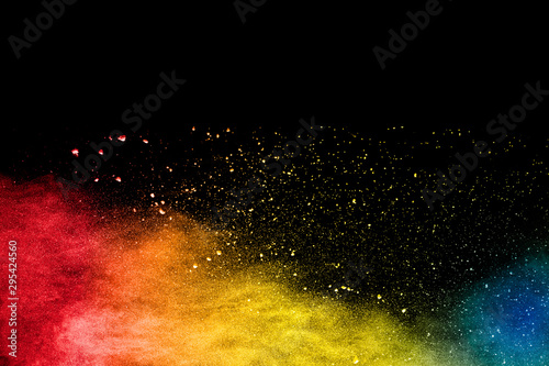 Colorful powder explosion on black background. Abstract pastel color dust particles splash.