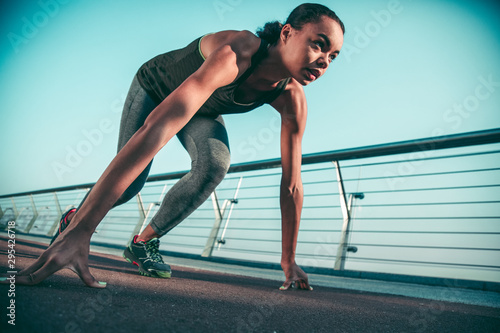 Professional sportswoman with hands on the ground stock photo