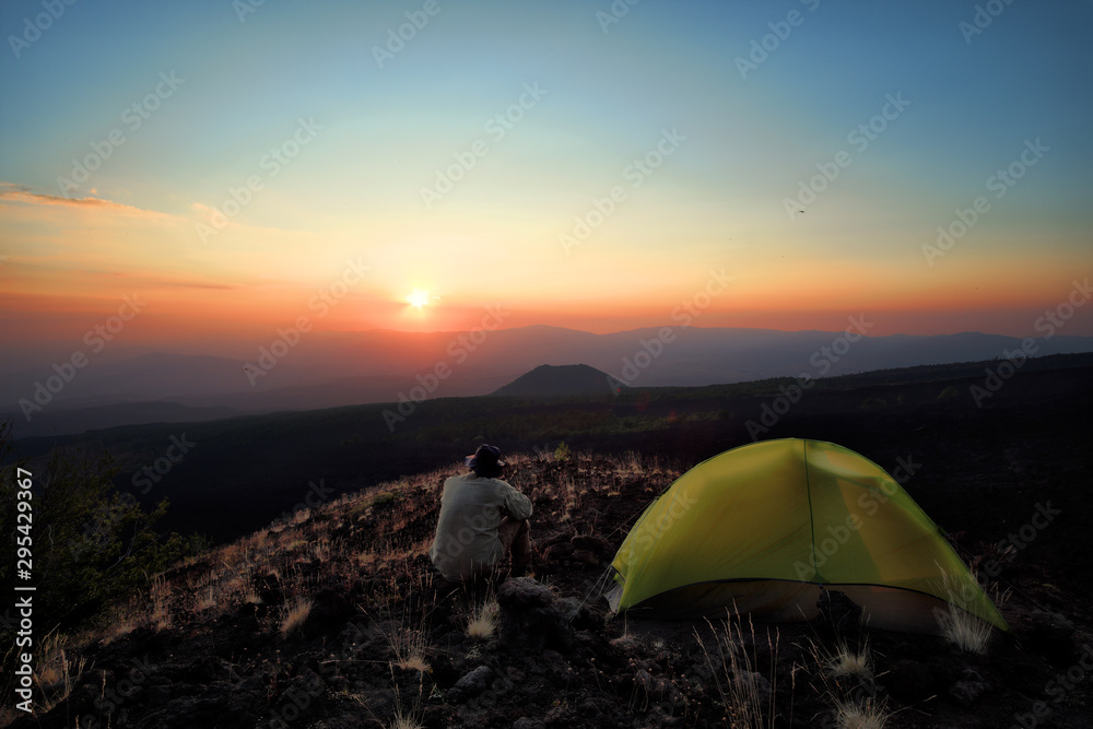 Hiker Overlooking Sunset From Wild Camp In Etna Park, Sicily