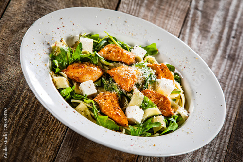 Pasta with chicken meat, feta cheese and rucola