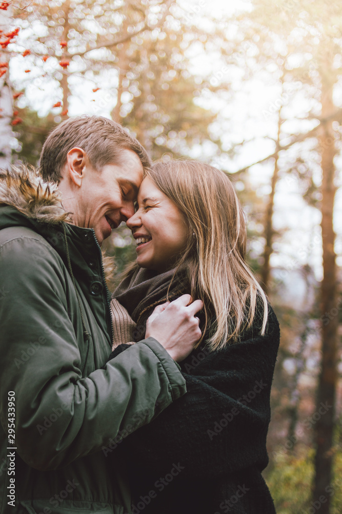 Fototapeta premium Happy young couple in love friends dressed in casual style walking together on nature park forest in cold season, family advenure travel