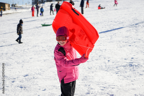 Little girl sledding at Sierra Nevada ski resort.