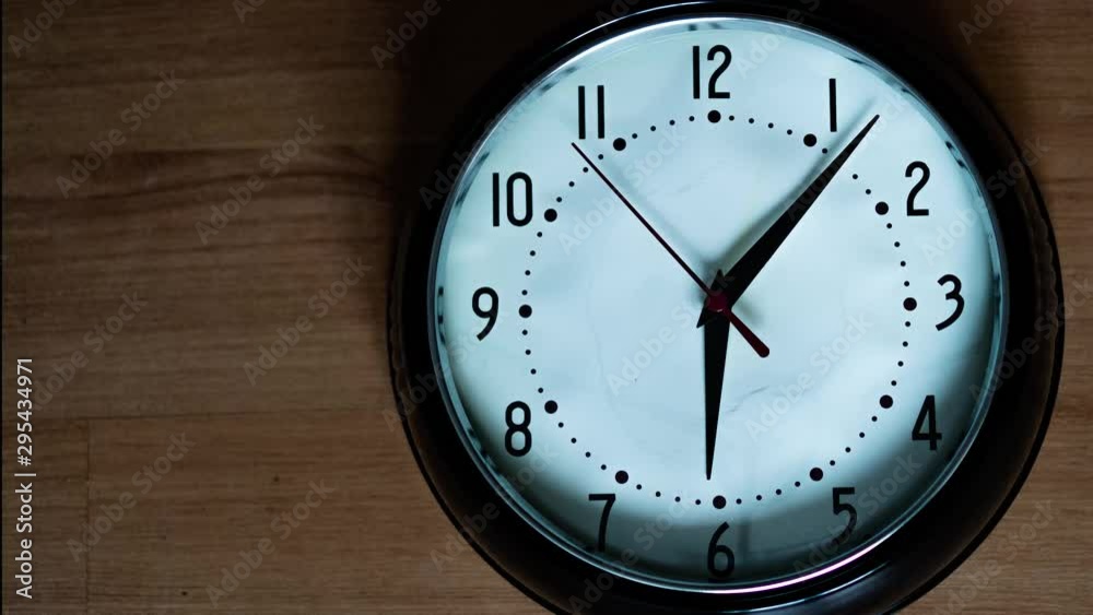 Oval black and white classic analog clock with red second hand going slowy arround. Passing the time time lapse Oval black and white classic analog clock with red second hand going slowy arround. Passing the time time lapse