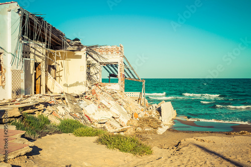 destroyed building on the beach after a storm due to strong waves. Climate change
