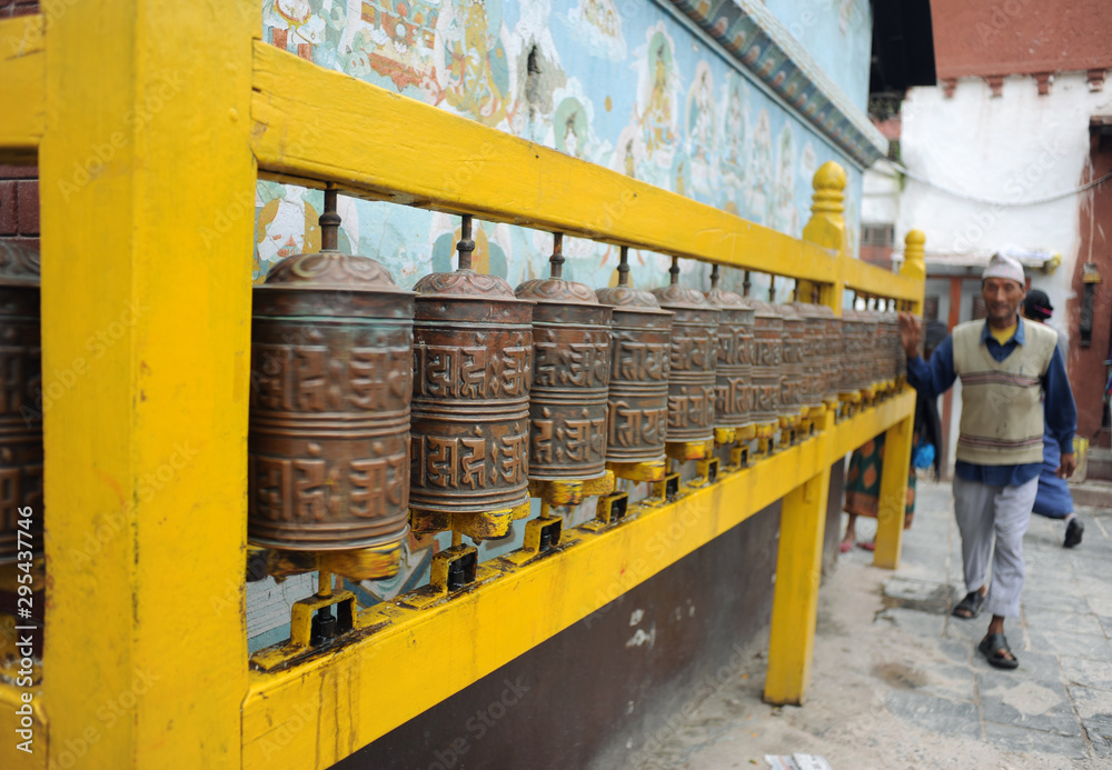 A devotee spinning the prayer wheels at the Boudha Stupa A devotee spinning the prayer wheels at the Boudha Stupa