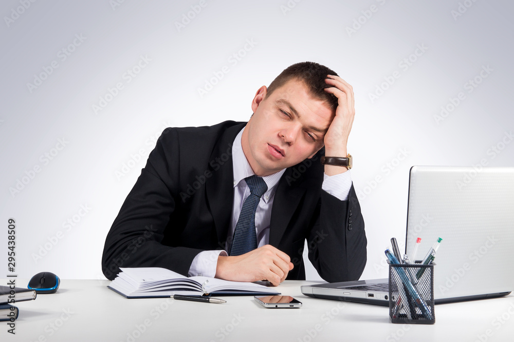 Office, finances, internet, business, success and stress concept-Frustrated young businessman working on laptop computer at office