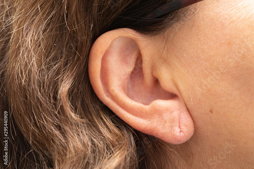 Female earlobe with piercing hole mark, ageing external ear skin photo
