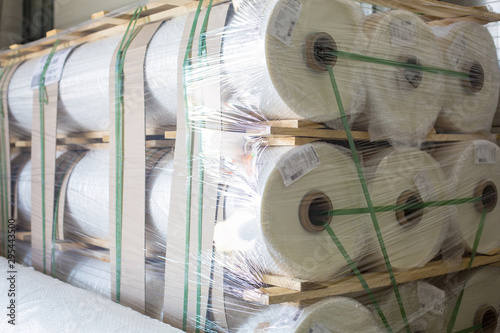 Warehouse with new plastic wrap rolls stretch packed on pallets for polycarbonate production