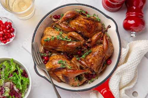 Fotografie Roasted quail with cranberry and thyme on pan
