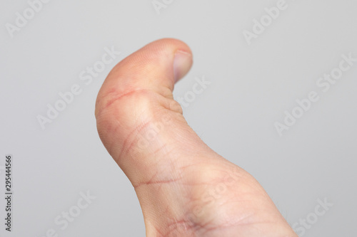 Human thumb close up on white background