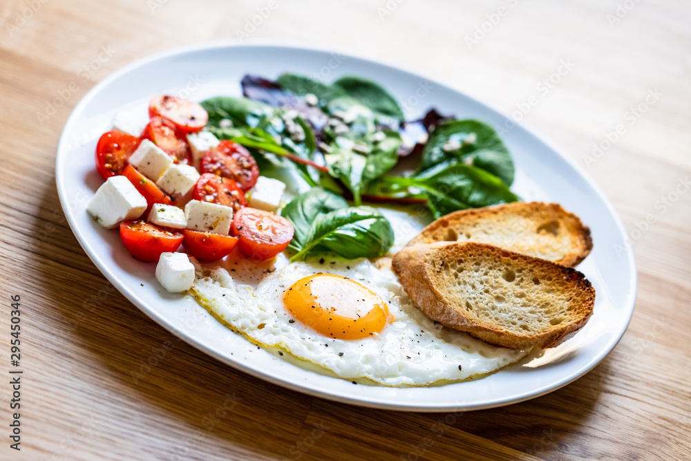 Breakfast - fried egg, toasts and vegetable salad