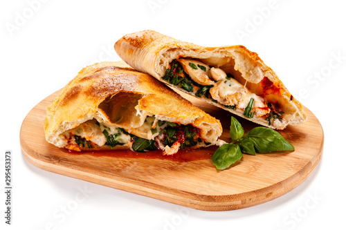 Pizza calzone on cutting board on white background photo
