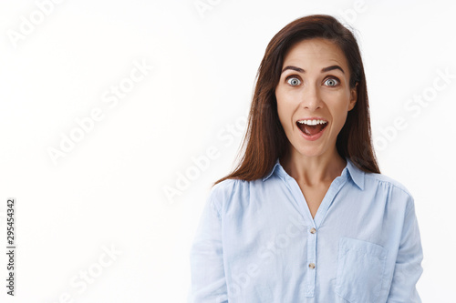 Amused cheerful adult 30s housewife look impressed, open mouth fascinated surprised, smiling excited, participate interesting event, stare camera wondered enthusiastic, white background