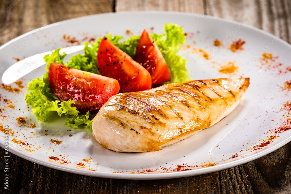Grilled chicken fillet and vegetables on white plate Grilled chicken fillet and vegetables on white plate