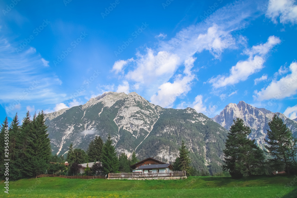 Old traditional farmhouse on top of a hill in scenic wonderland scenery in the Alps. Old traditional farmhouse on top of a hill in scenic wonderland scenery in the Alps.