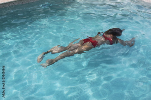 Frau taucht im Swimmingpool im Urlaub