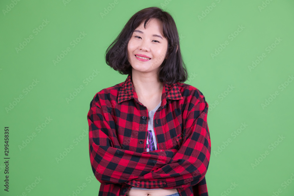 Portrait of happy Asian hipster woman smiling with arms crossed Portrait of happy Asian hipster woman smiling with arms crossed