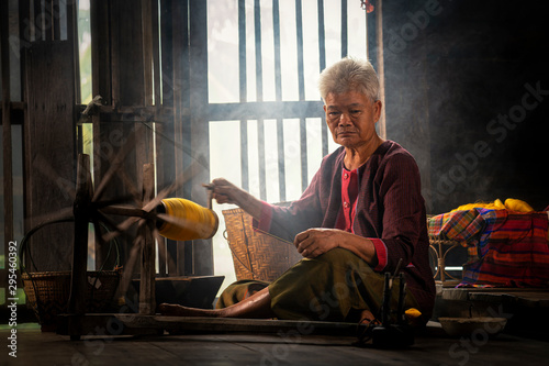 Craftsmen of Thai Silk. Local teachers is master are the original silk weaving in the community of Buriram province. Thai old woman shows weaving spinning natural colorful threads or yarn.