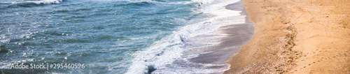 Close up of the sea water affecting the sand on the beach, sea waves calmly flowing sand, relaxing view