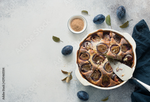 Rustic plum cake on a grey stone background