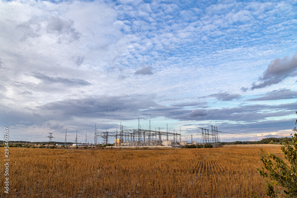 Electrical sub station against the cloudy sky. Energy generation landscape.