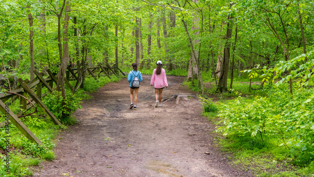 Mother and teen daughter walking down path Mother and teen daughter walking down path