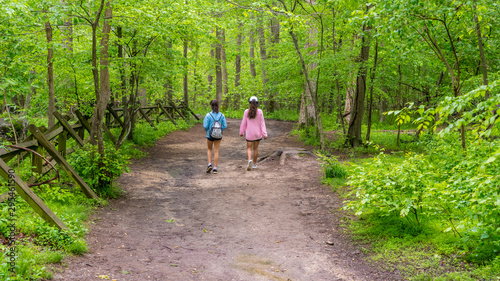 Mother and teen daughter walking down path © David