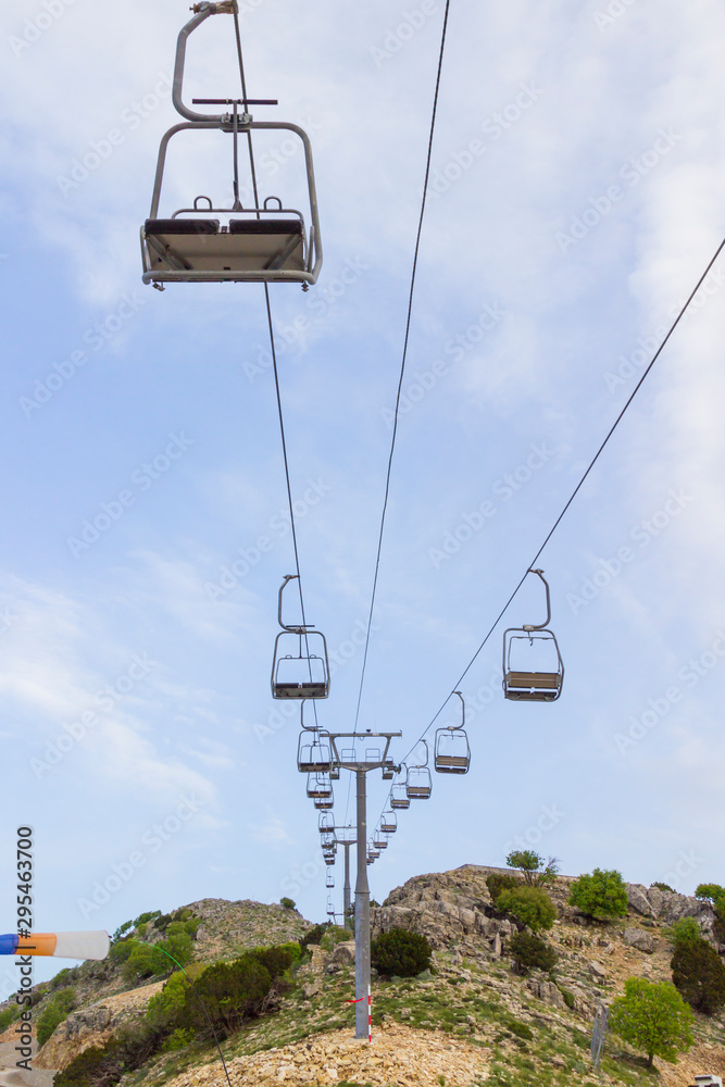 An empty ski lift on a sunny summer day. Mountain slopes.