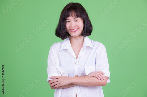 Portrait of happy Asian businesswoman smiling with arms crossed © Ranta Images