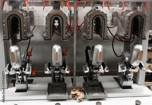 Man use special machine tool for making a shoes. The conveyor on a shoes factory with shoe and sole. Mass production of footwear.