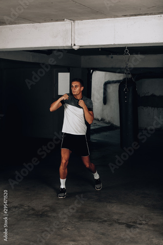 Handsome young boxer during boxing exercises