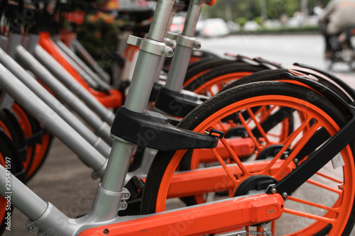 Wallpaper Mural Street transportation orange hybrid rent bicycles with electronic form of payment for traveling around the city stand in row on rental network parking lot waiting for cyclists to make bike trip. Torontodigital.ca