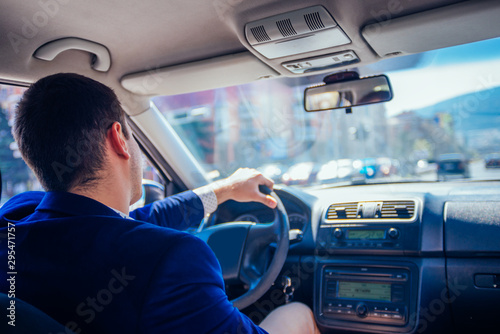 Reckless businessman driving in the city during the rush hour while doing corporate work on his tablet. © qunica.com